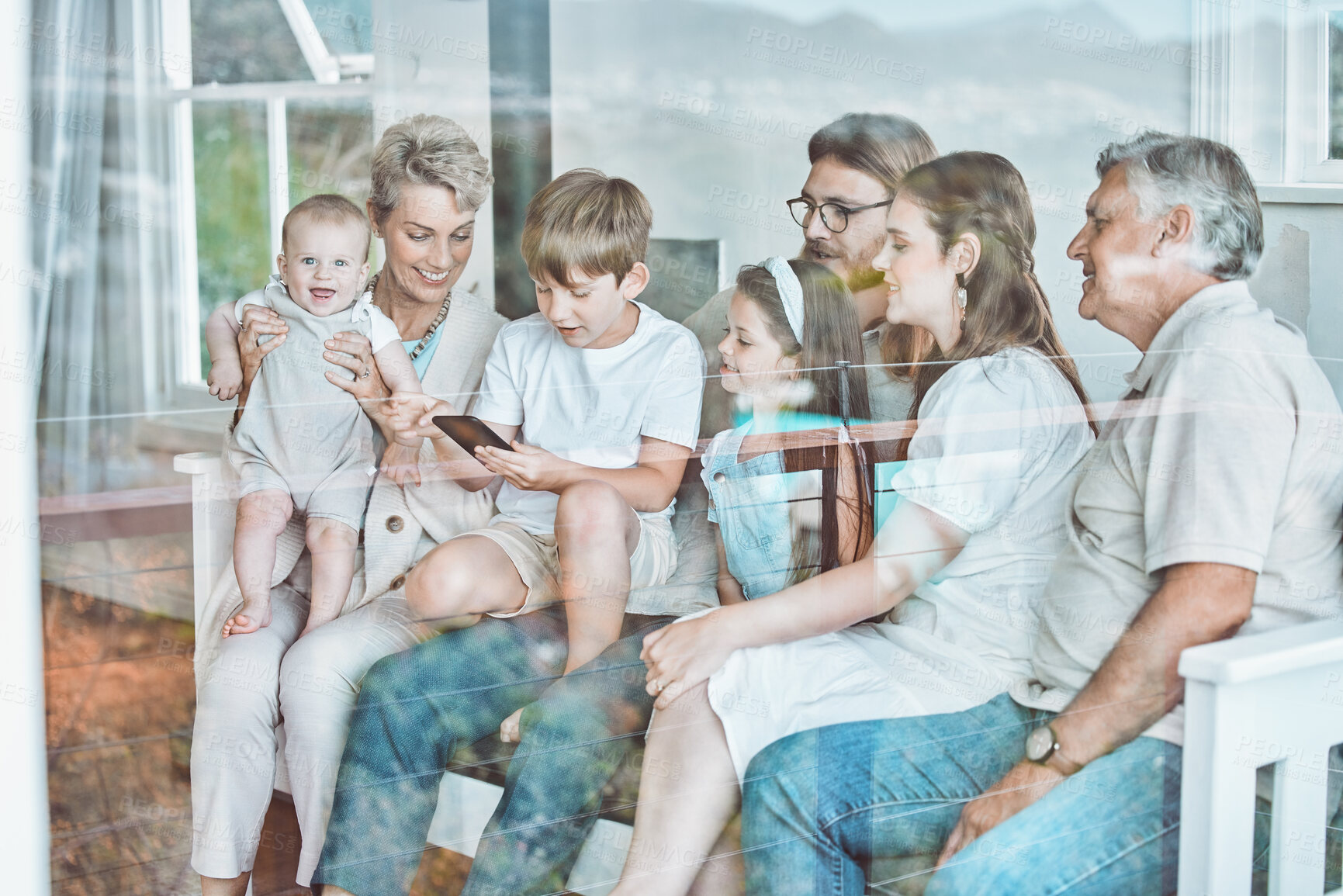 Buy stock photo Big family, mobile phone and bonding in home with children, streaming or application on weekend in lounge. People, kids and tech for connection, together or relax with grandparents, play and cheerful