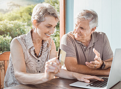 Buy stock photo Shot of a mature couple sitting together while using a laptop and a credit card
