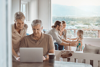 Buy stock photo Shot of a senior couple using a laptop while a young family sits in the background