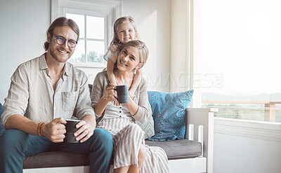 Buy stock photo Shot of a couple drinking coffee while sitting at home with their daughter