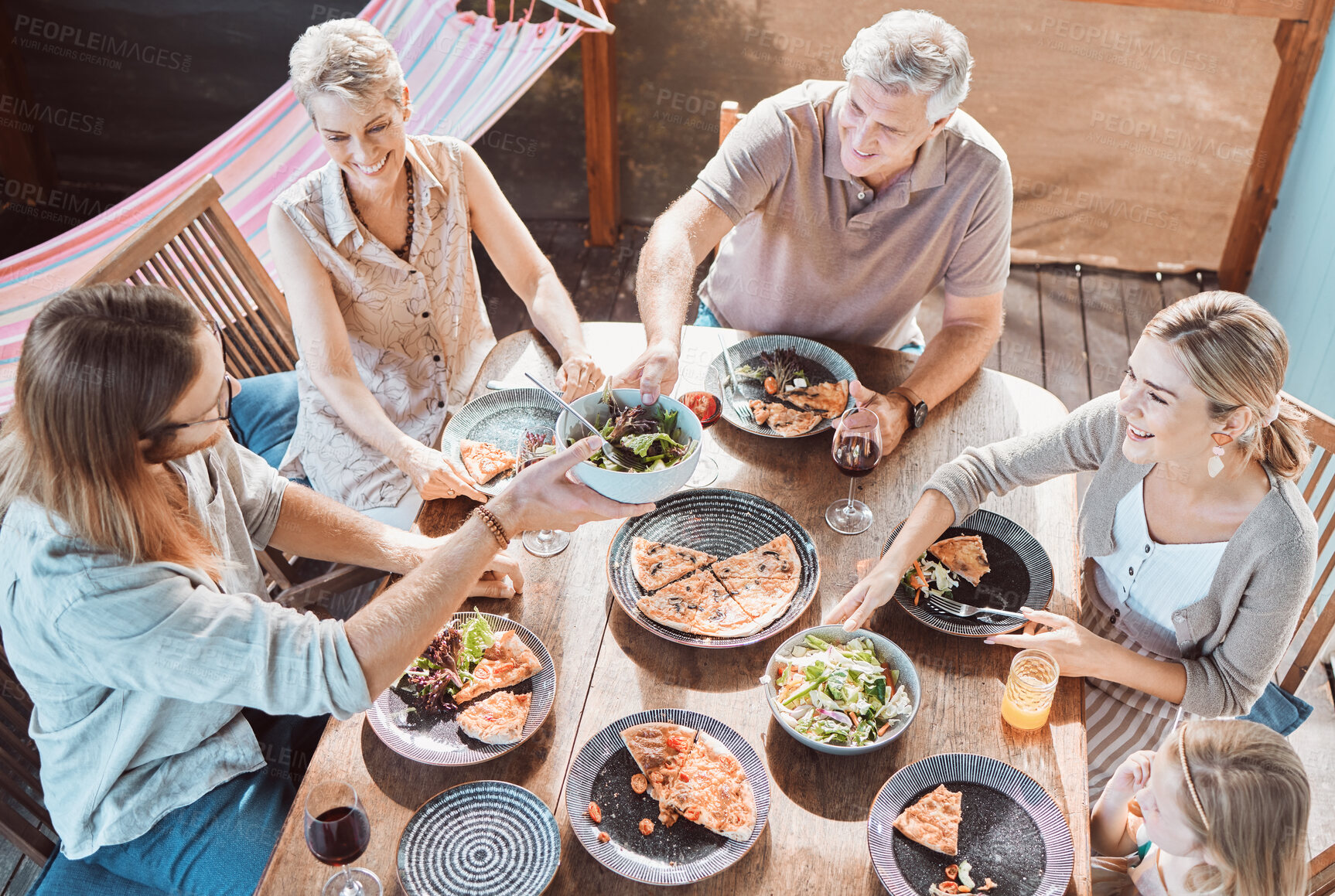 Buy stock photo Lunch, table and family sharing food, smile and weekend gathering with bonding event on patio. Grandparents, parents and child in backyard eating together for dinner celebration on terrace at home