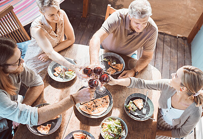 Buy stock photo High angle shot of a family sitting together and toasting with wine during lunch