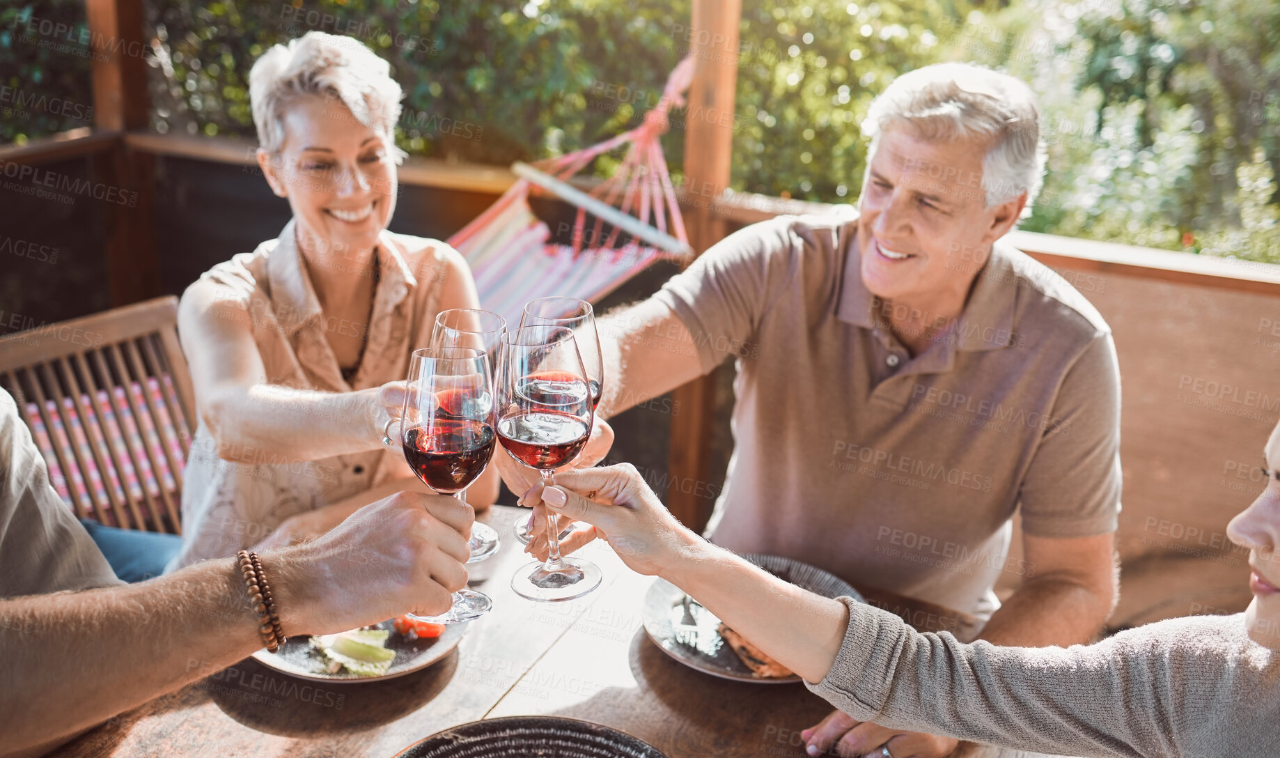 Buy stock photo Lunch, cheers and family at table with wine, smile and weekend gathering event on patio. Men, women and toast with glass, eating food together and sharing happy dinner celebration on terrace at home