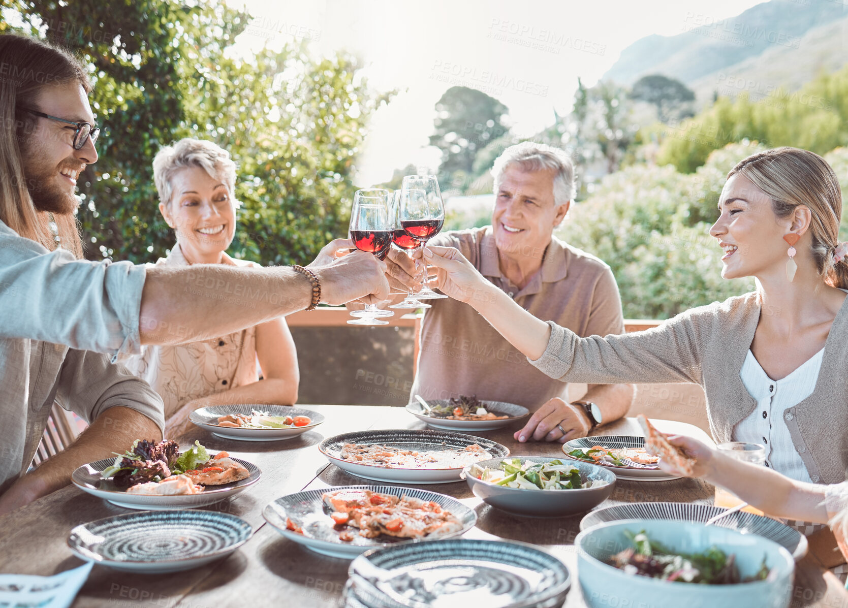 Buy stock photo Smile, cheers and family with wine, food and brunch at weekend lunch gathering event on patio. Men, women and toast with glass, eating together and happy dinner celebration on terrace at home