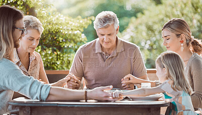 Buy stock photo Shot of a family sitting together and praying before lunch