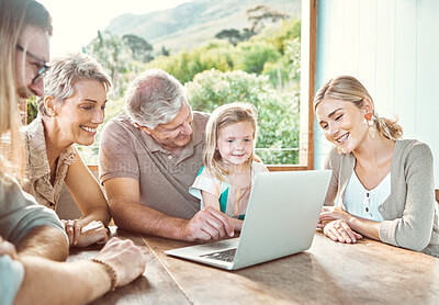 Buy stock photo Shot of a family sitting together and using a laptop