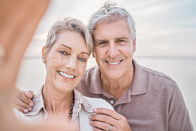 Buy stock photo Shot of a mature couple taking a selfie while at the beach