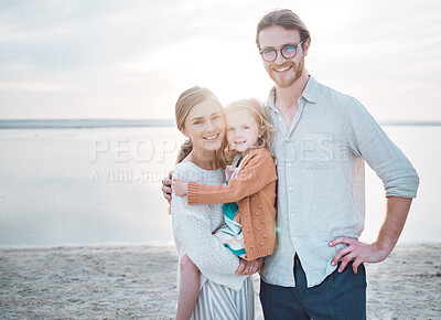 Buy stock photo Shot of a couple and their daughter spending the day at the beach