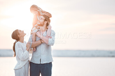 Buy stock photo Shot of a couple and their daughter spending the day at the beach