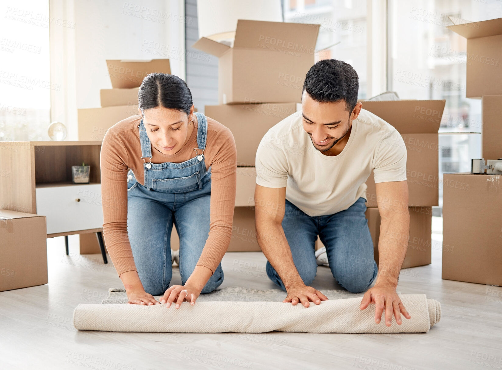 Buy stock photo Moving, couple and new home with carpet and decoration for living room with boxes and real estate. Teamwork, support and help with interior design, furniture and rug roll together with smile in floor