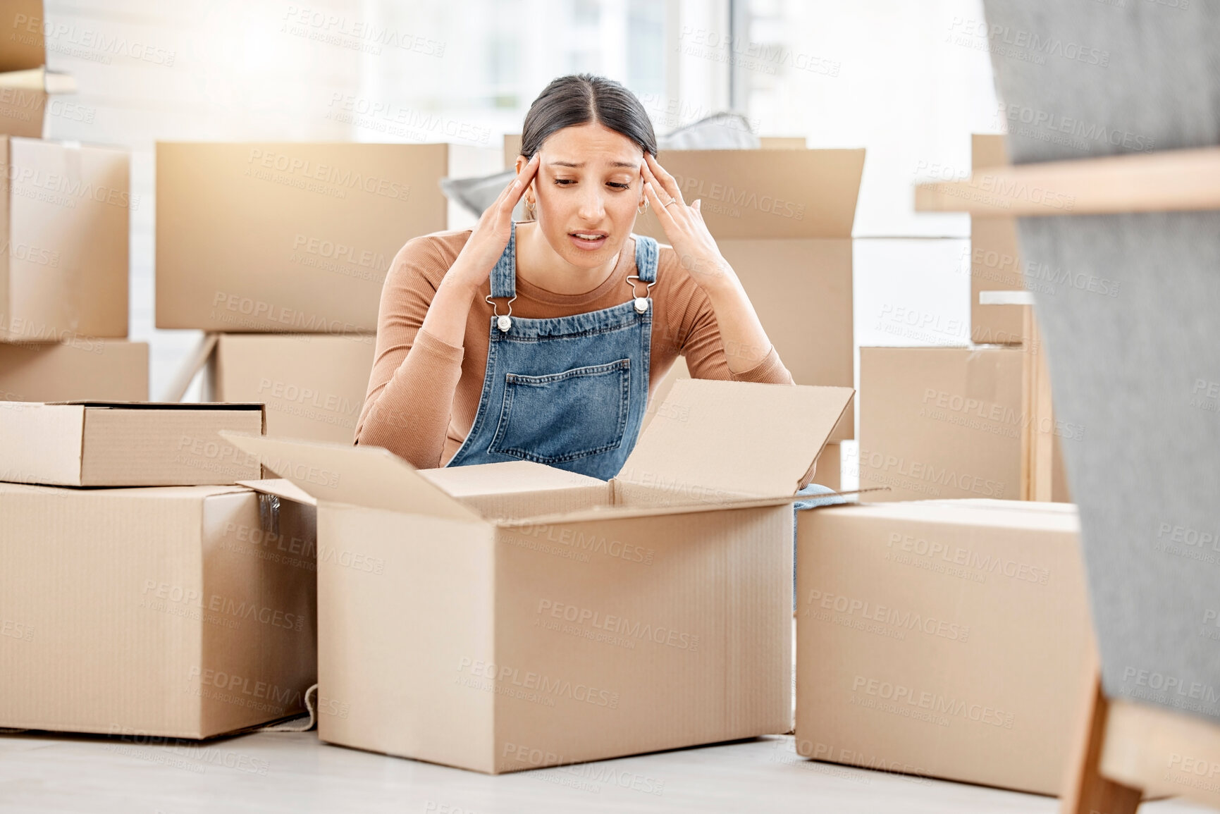 Buy stock photo Stress, moving house and woman with boxes, headache and fatigue from real estate or investment. Frustrated, packing and female person in new apartment or property with fear for eviction and rent