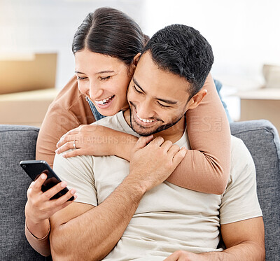 Buy stock photo Shot of a young couple using a cellphone while moving house