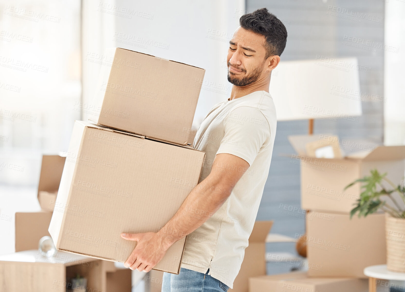 Buy stock photo Man, boxes and house moving for property, walking with struggle or heavy cargo in apartment. Male person, carrying and cardboard container in home for real estate, difficult relocation for investment