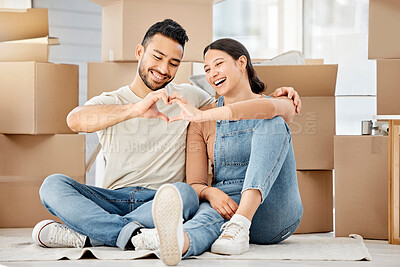 Buy stock photo Shot of a young couple making a heart shape with their hands while moving house