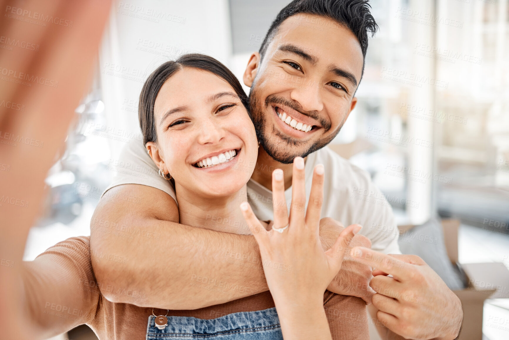 Buy stock photo Engagement, hug and selfie with couple in new home together for celebration of property investment. Face, ring or smile with happy man and woman in apartment for bonding, commitment or real estate