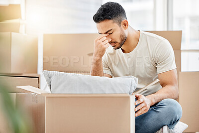Buy stock photo Shot of a young man looking unhappy while moving house