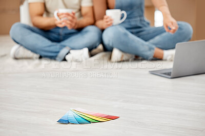 Buy stock photo Closeup shot of colour swatches on the floor with an unrecognisable couple using a laptop in the background while moving house