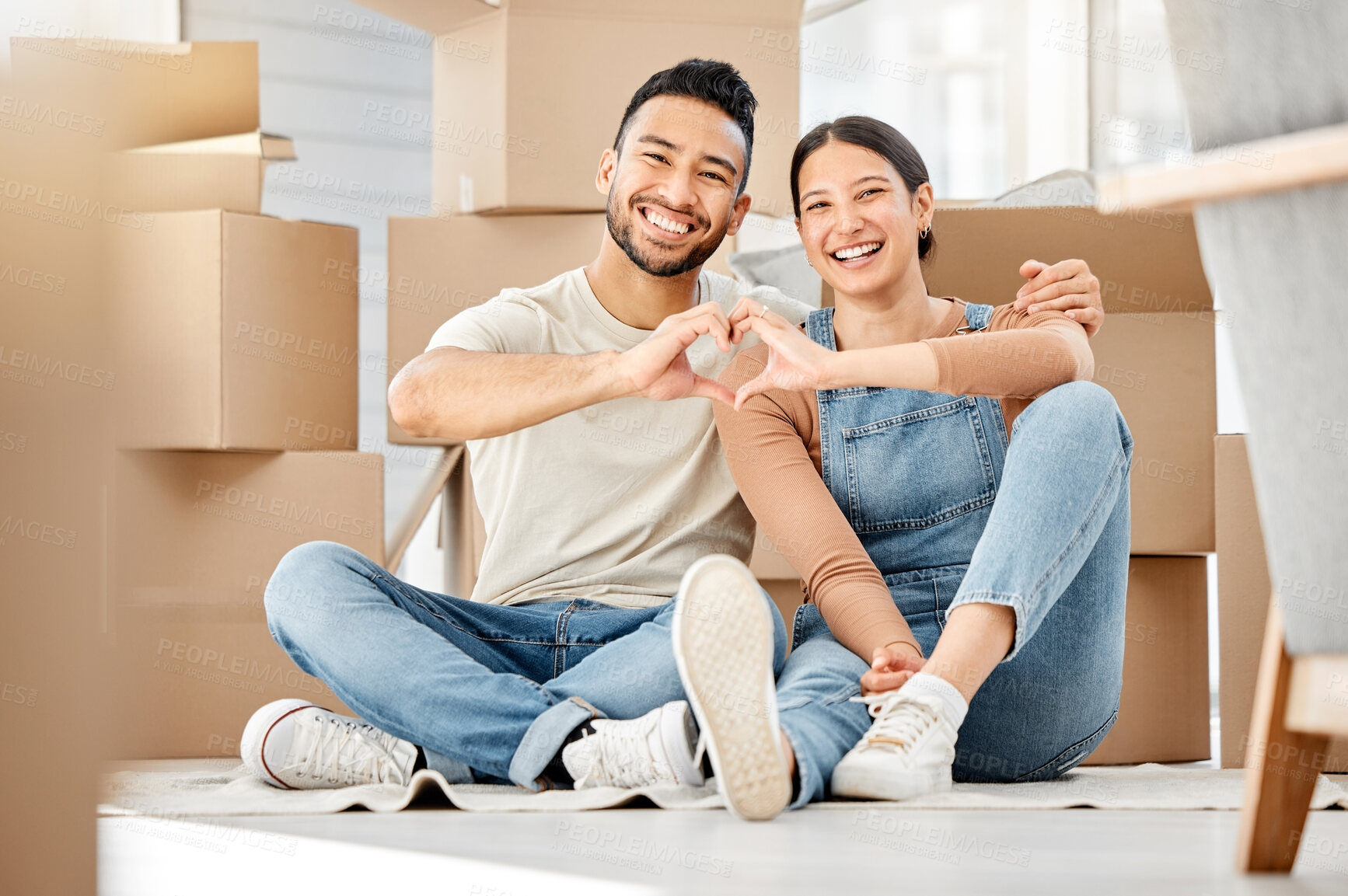 Buy stock photo Portrait of a young couple making a heart shape with their hands while moving house