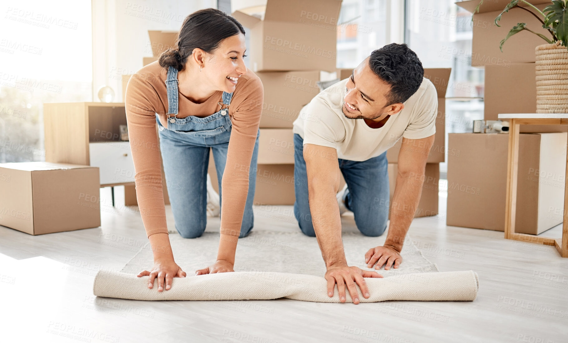 Buy stock photo Moving, couple and home with carpet and decoration for living room with boxes and real estate. Teamwork, support and help with interior design, furniture and rug roll together with smile and people