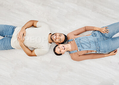 Buy stock photo High angle shot of a young couple lying on the floor while moving house