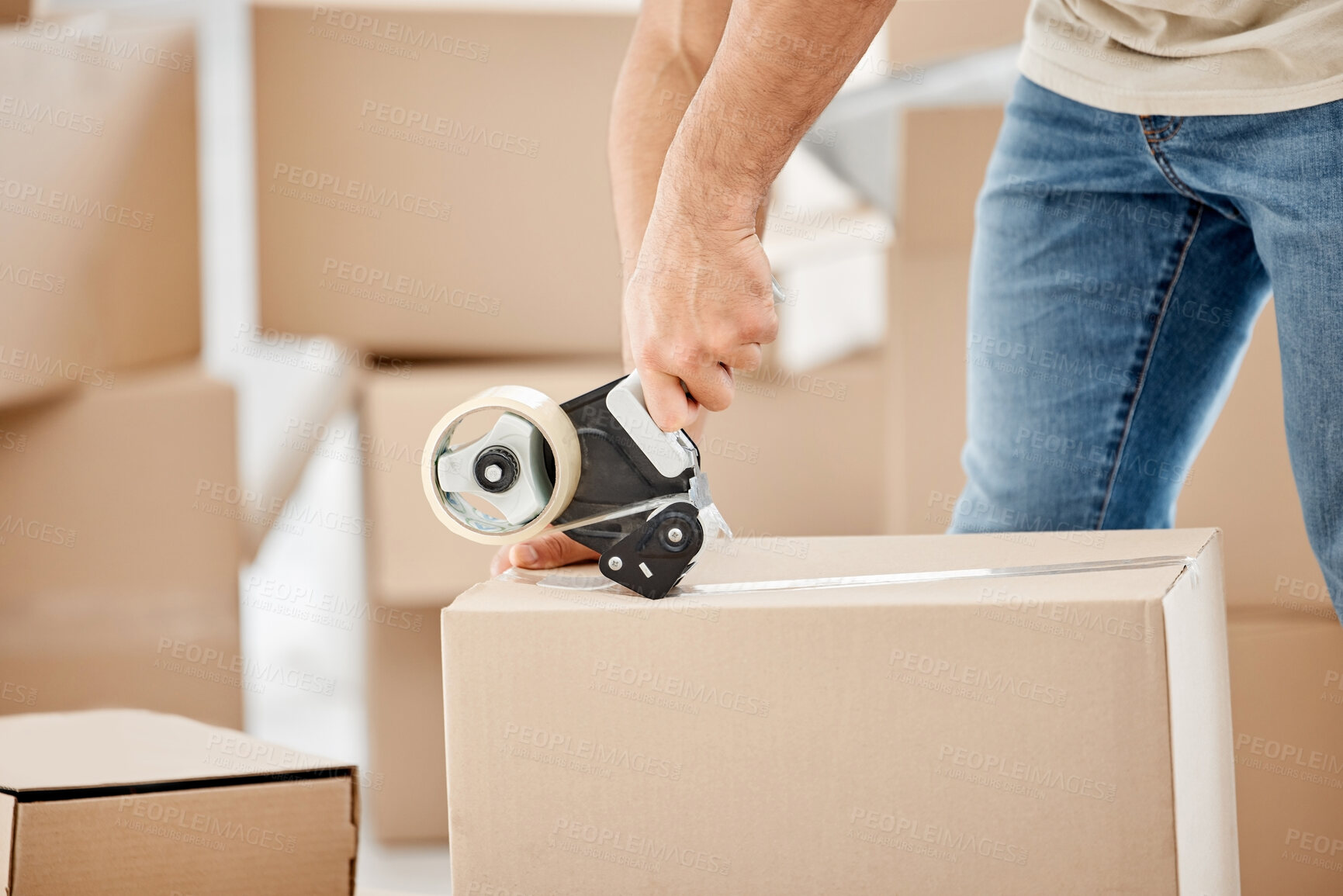 Buy stock photo Closeup shot of an unrecognisable man using  a tape dispenser while moving house
