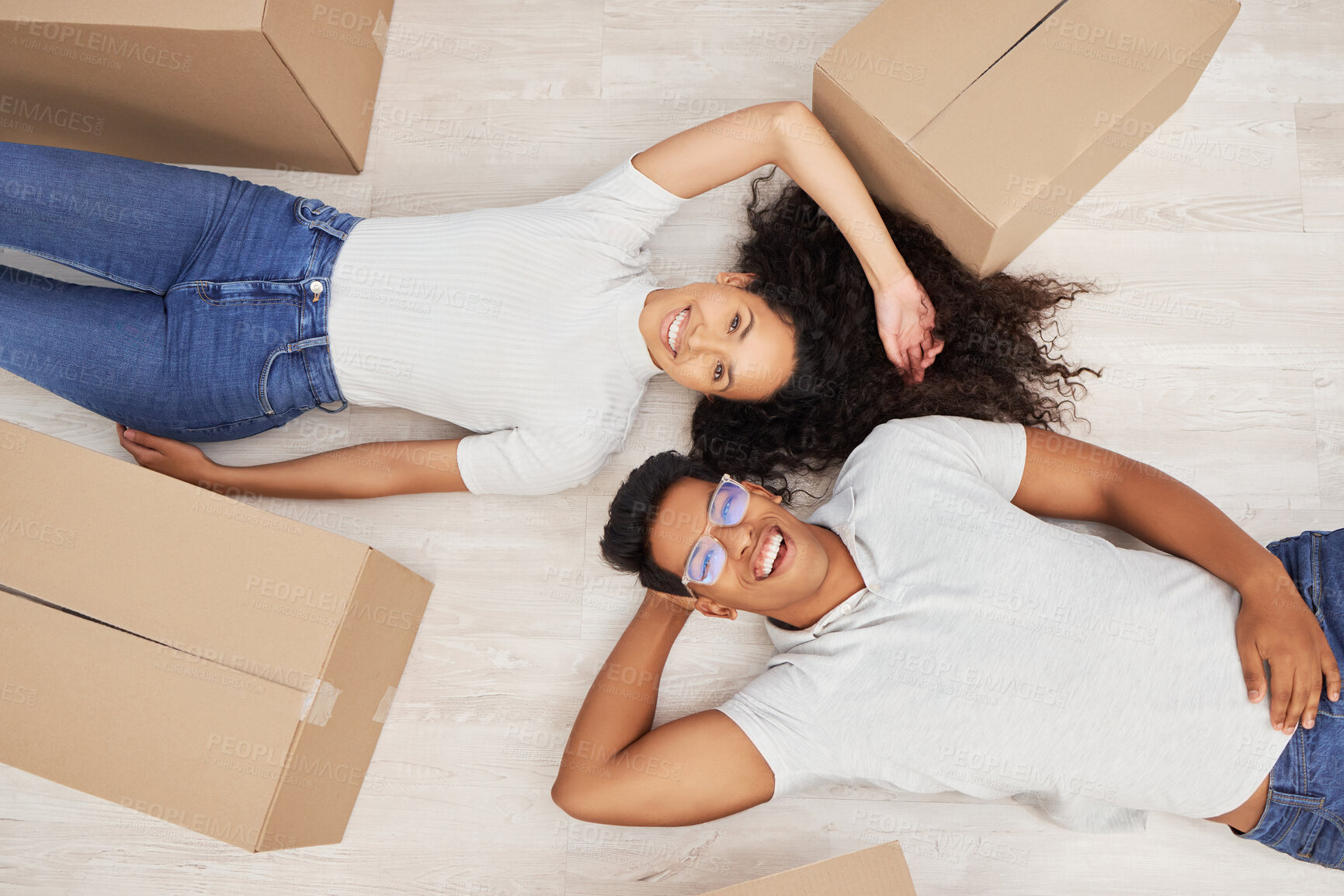 Buy stock photo Portrait, top view and happy couple in new home with boxes for real estate, mortgage and investment. Relax, woman and laughing man rent property, apartment or excited for relocation on floor together