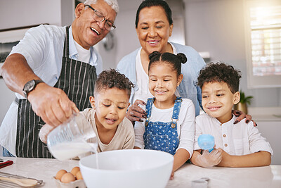 Buy stock photo Shot of a mature couple baking with their grandkids at home