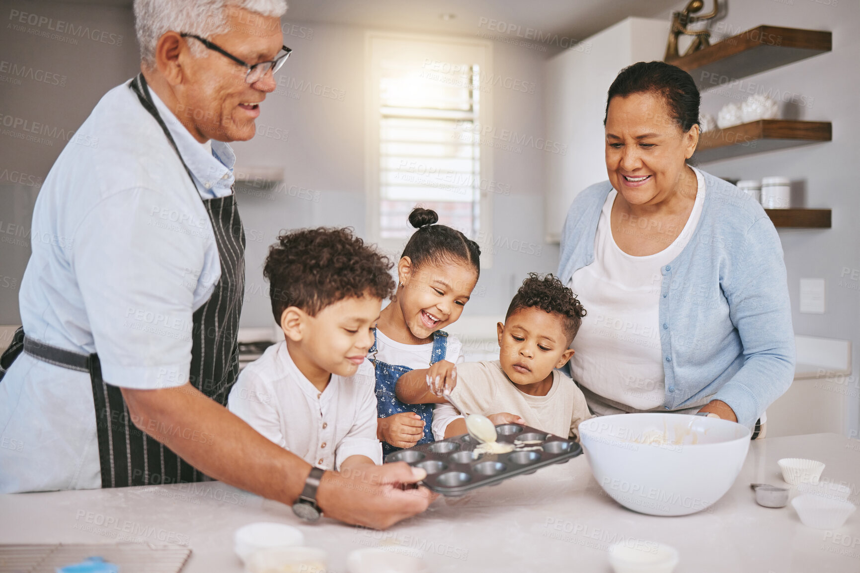 Buy stock photo Shot of a mature couple baking with their grandkids at home