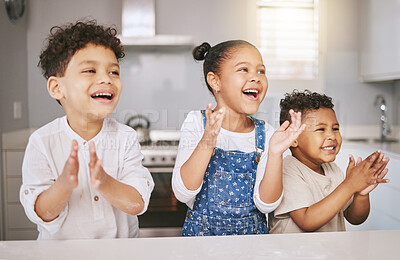 Buy stock photo Shot of three cheerful siblings celebrating while baking in a kitchen