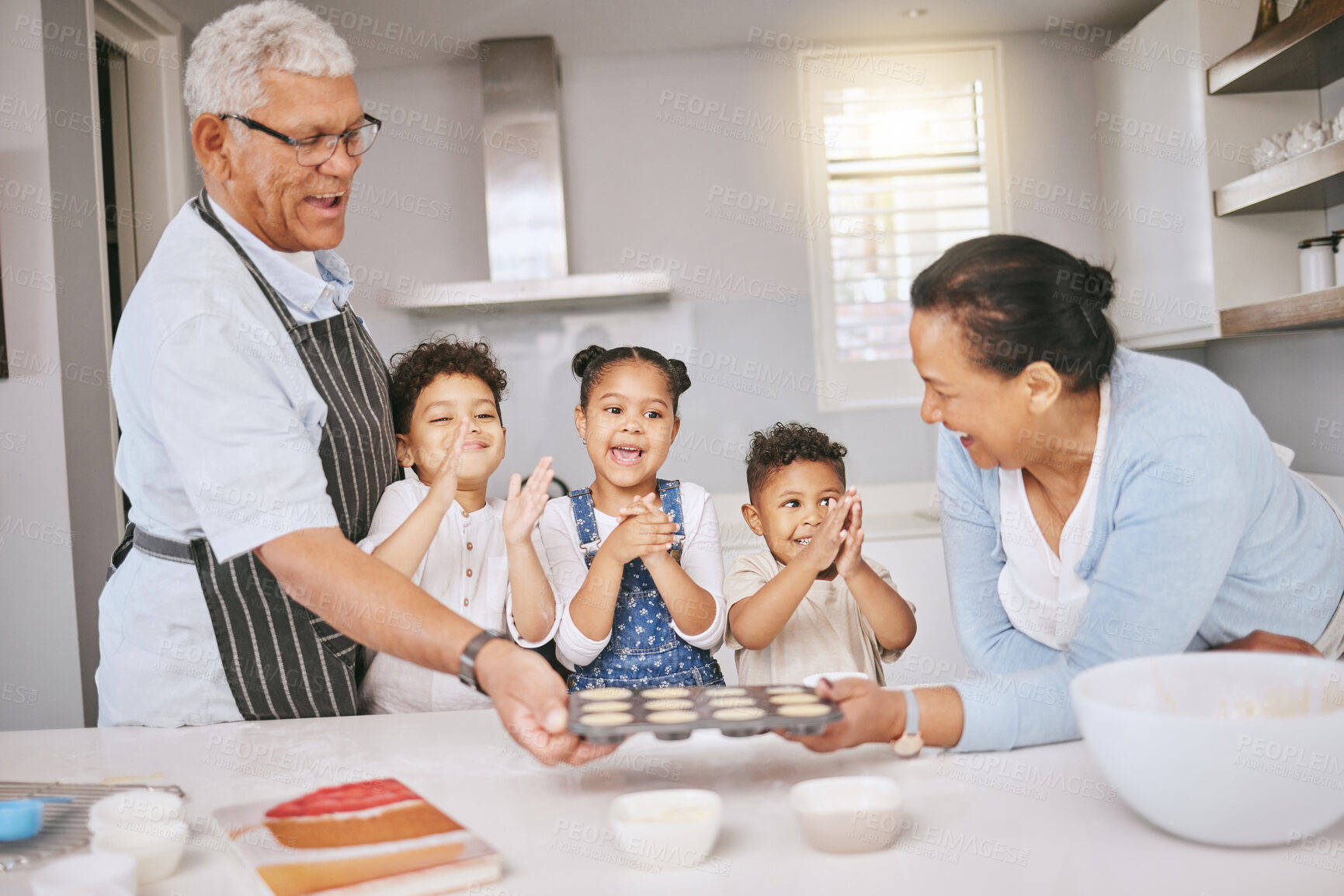 Buy stock photo Shot of a mature couple baking with their grandkids at home