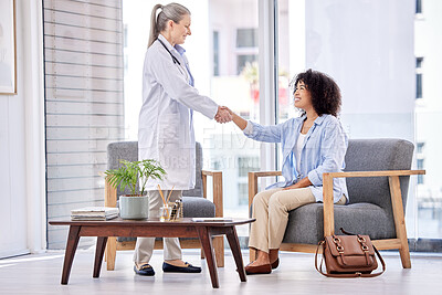 Buy stock photo Shot of a mature female doctor shaking hands with a patient in an office