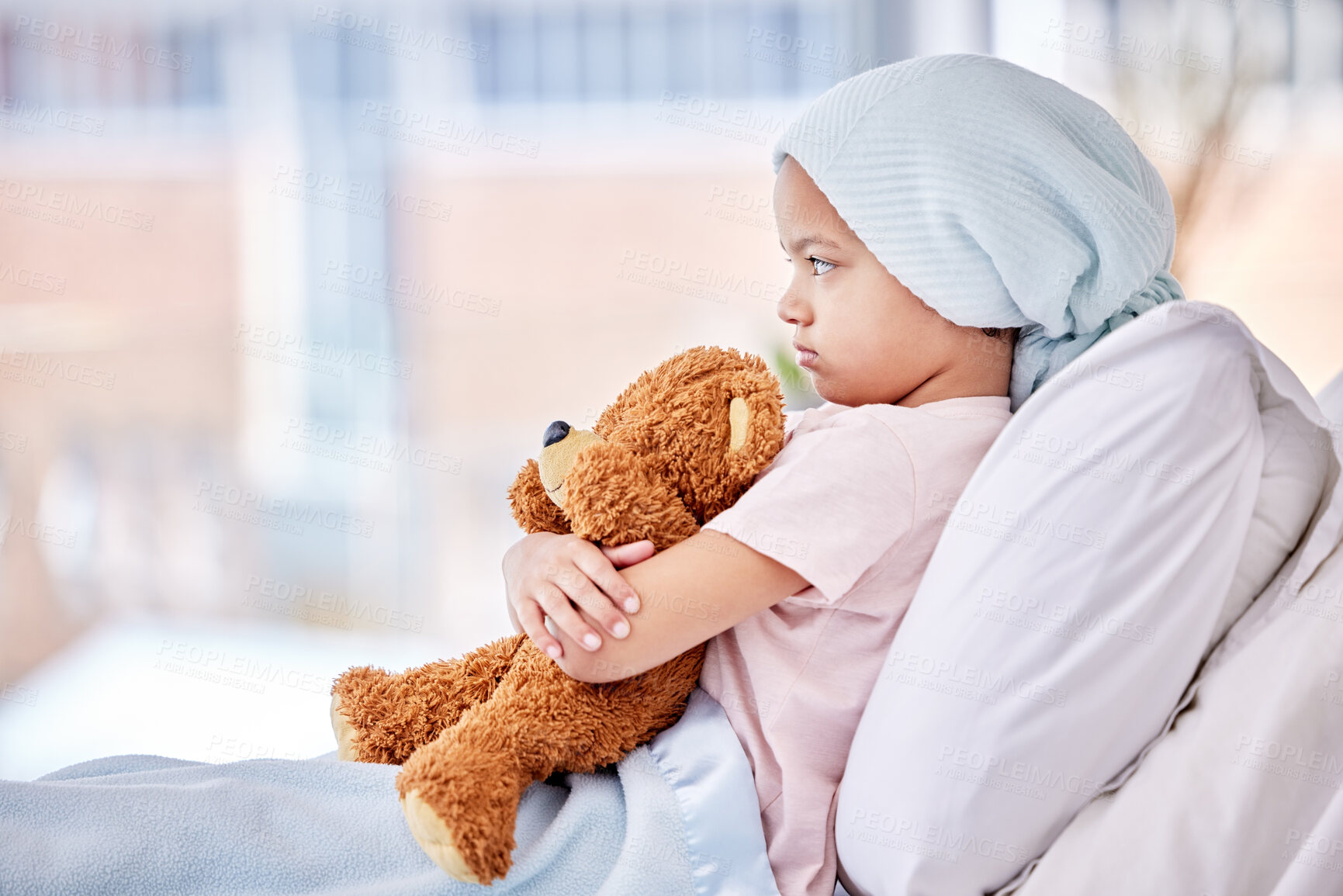 Buy stock photo Teddy bear, sick and child in bed at hospital in recovery with chemotherapy treatment for cancer. Sad, patient and girl kid with leukemia hug toy for comfort at medical radiation in pediatric clinic.