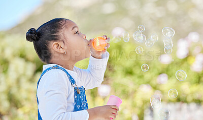 Buy stock photo Child, girl and blowing bubbles outdoor for sensory play, childhood development and fun activity in nature. Kid, plastic toy and game with freedom, imagination or entertainment for creativity in park