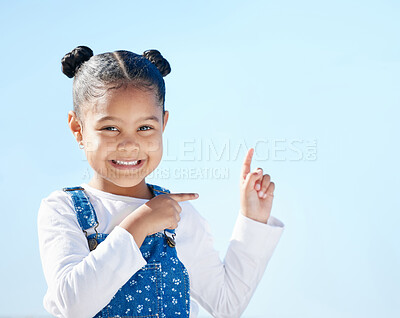 Buy stock photo Shot of a little girl pointing to the sky while standing outside