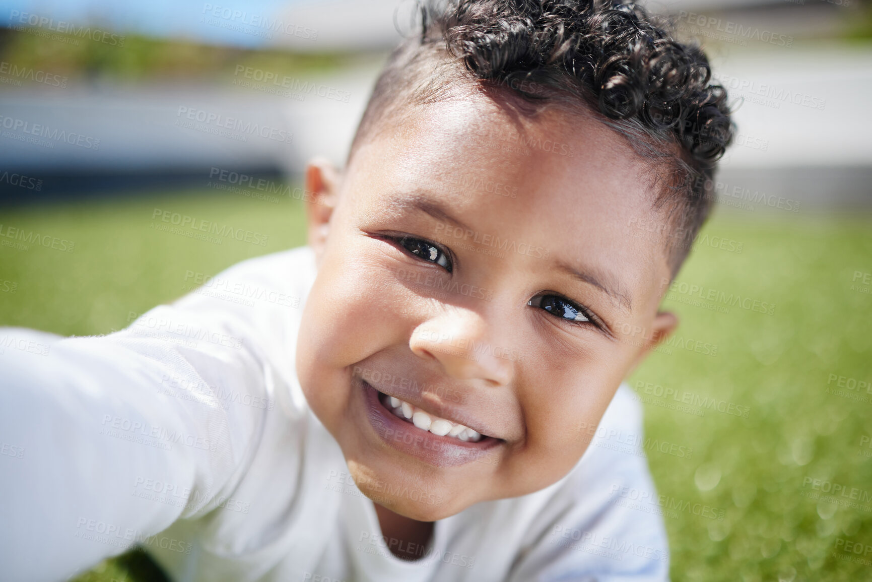 Buy stock photo Happy boy, portrait and lying with selfie on grass field for picture, photography or outdoor memory in backyard. Face, little child or kid with smile for playful weekend, moment or holiday in nature