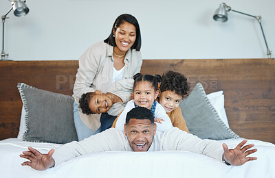 Buy stock photo Parents, children and happy for pile on bed for portrait with comic game, plane and bonding at family house. Father, mother and kids with piggy back, playful or smile together at apartment in Mexico