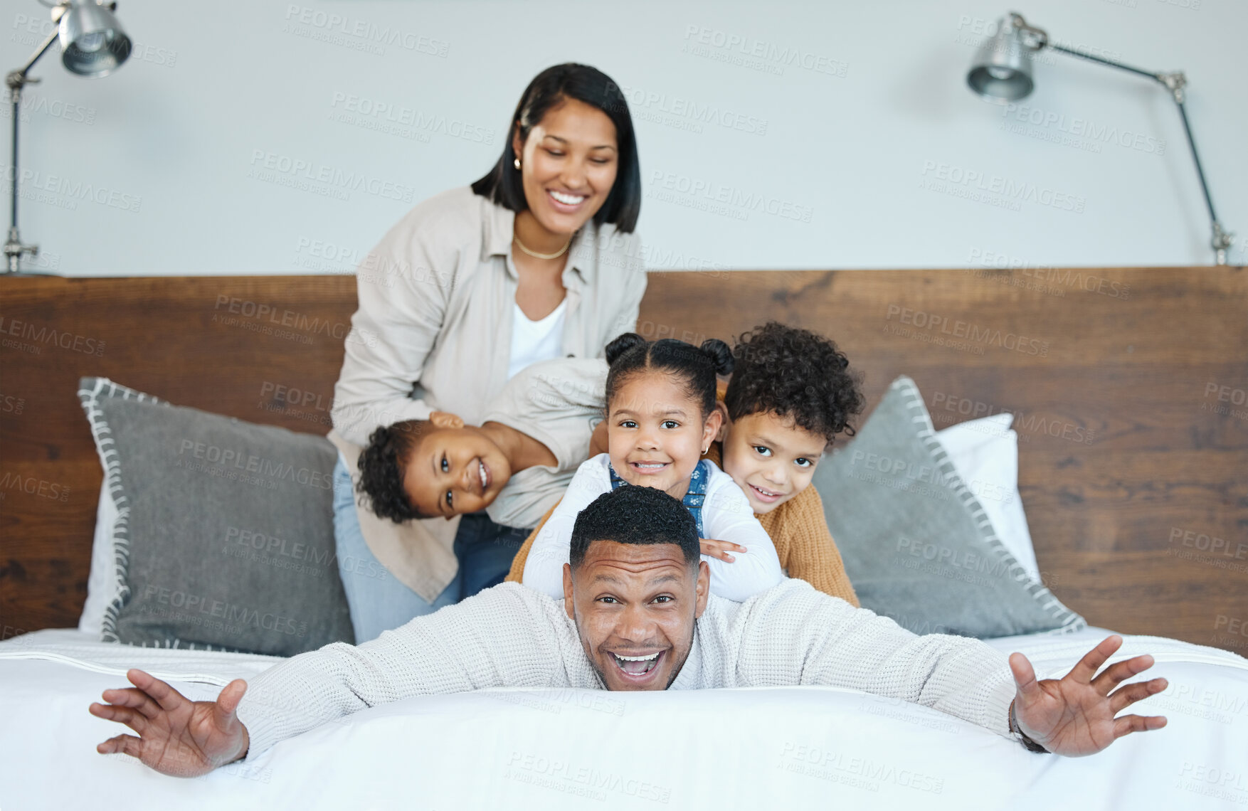 Buy stock photo Parents, children and happy for pile on bed for portrait with comic game, plane and bonding at family house. Father, mother and kids with piggy back, playful or smile together at apartment in Mexico