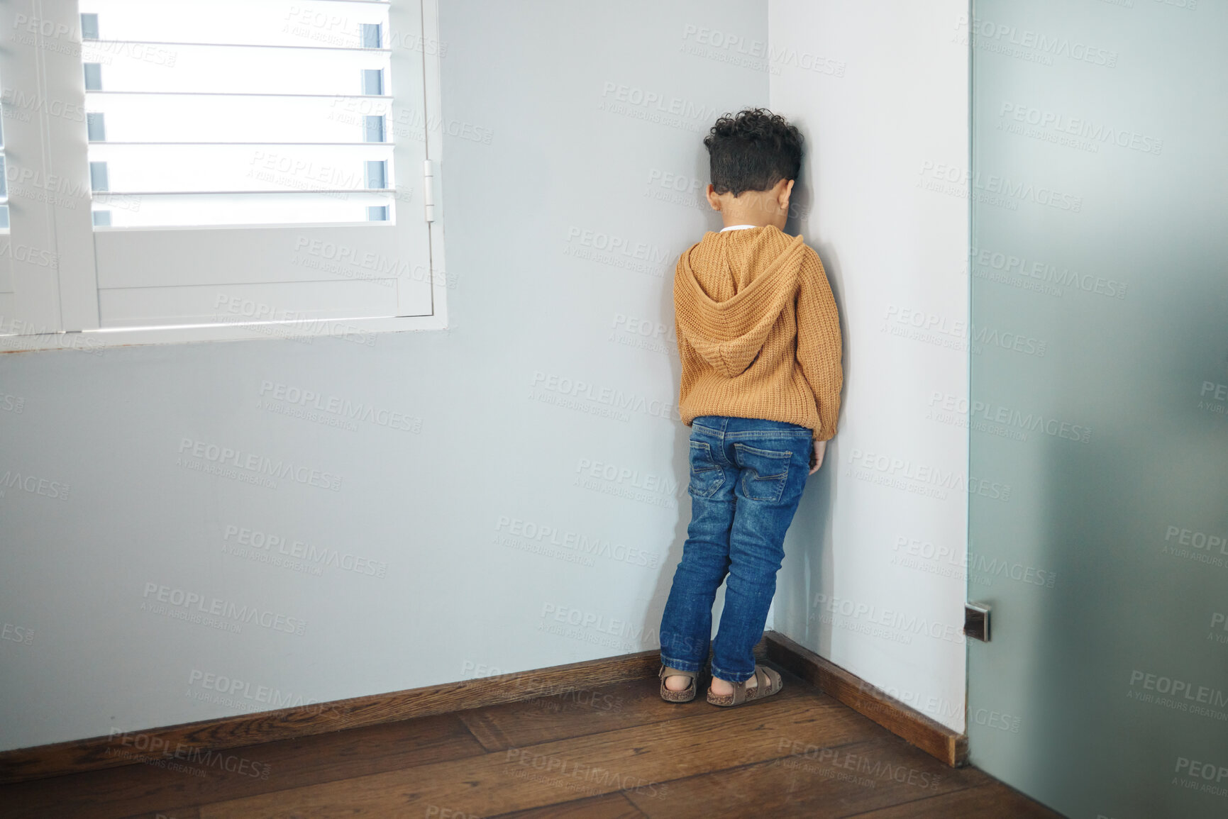 Buy stock photo Naughty kid, boy and back to wall in home for punishment, behavior and discipline. Child, person with adhd and standing in corner of living room for time out, tantrum and expression of guilt in house