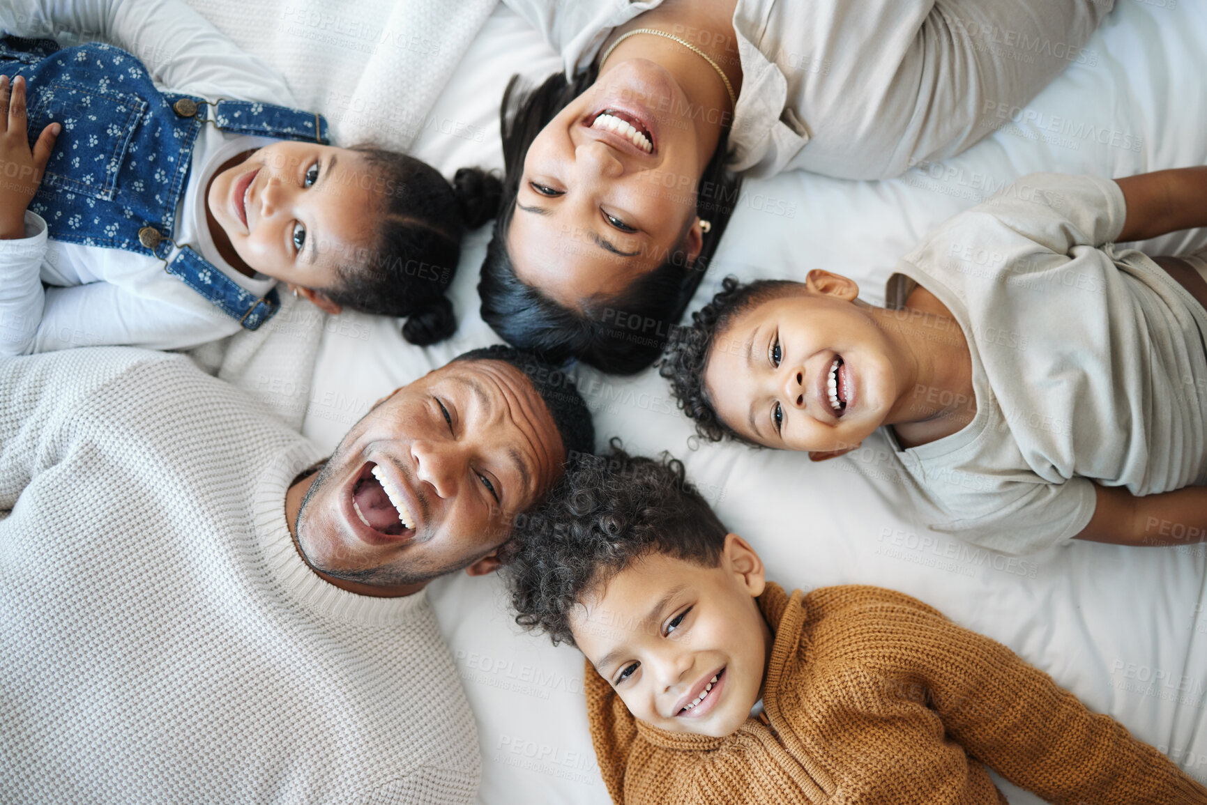 Buy stock photo Parents, kids and above bed with laughing, love and funny memory for connection in morning at family house. Father, mother and children with lying, portrait and happy for joke at apartment in Mexico