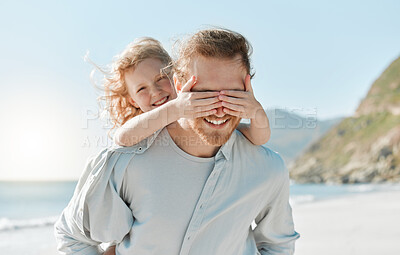 Buy stock photo Shot of a little girl covering her father's eyes while playing on the beach