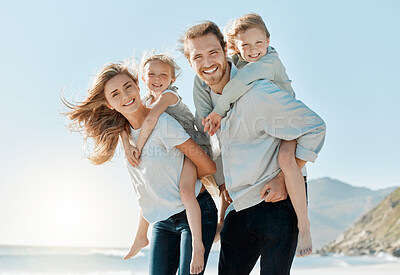 Buy stock photo Shot of a couple carrying their daughters on their backs while at the beach