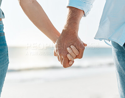 Buy stock photo Cropped shot of a mature couple holding hands on the beach