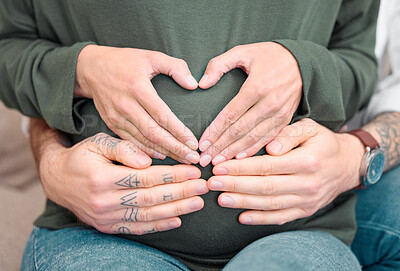 Buy stock photo Cropped shot of an unrecognizable couple sitting with their hands on the expectant mother's belly