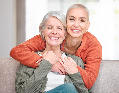 Buy stock photo Cropped portrait of an attractive young woman and her senior mother sitting on the sofa at home
