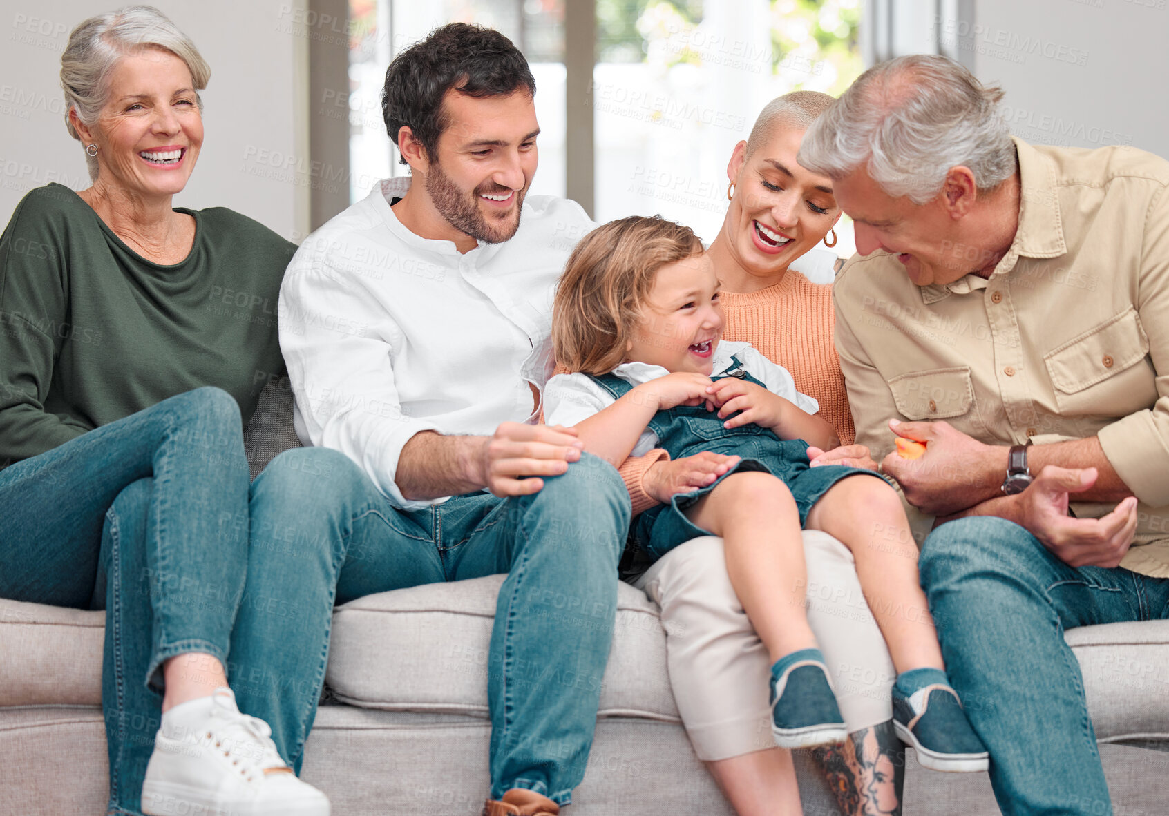 Buy stock photo Shot of a happy family bonding on the sofa at home