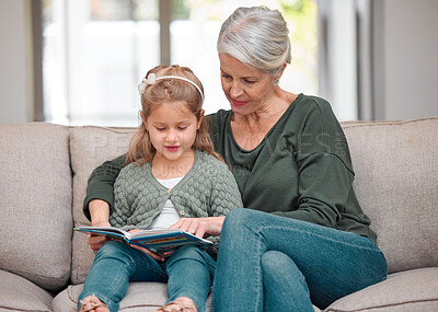 Buy stock photo Shot of a grandmother and granddaughter bonding on the sofa while using a digital tablet