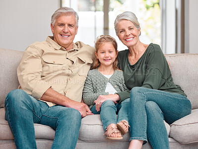 Buy stock photo Portrait of a mature couple bonding with their granddaughter on a sofa