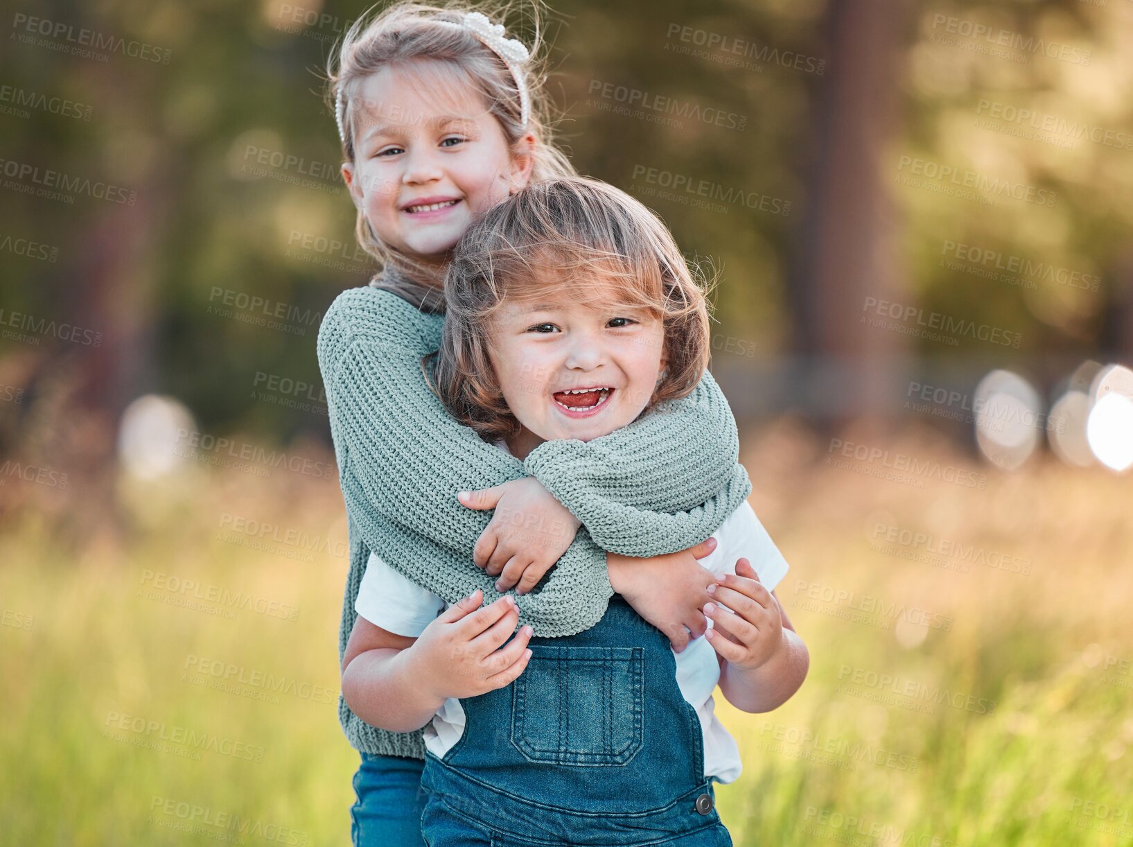 Buy stock photo Shot of an adorable little girl and her smaller brother standing outside