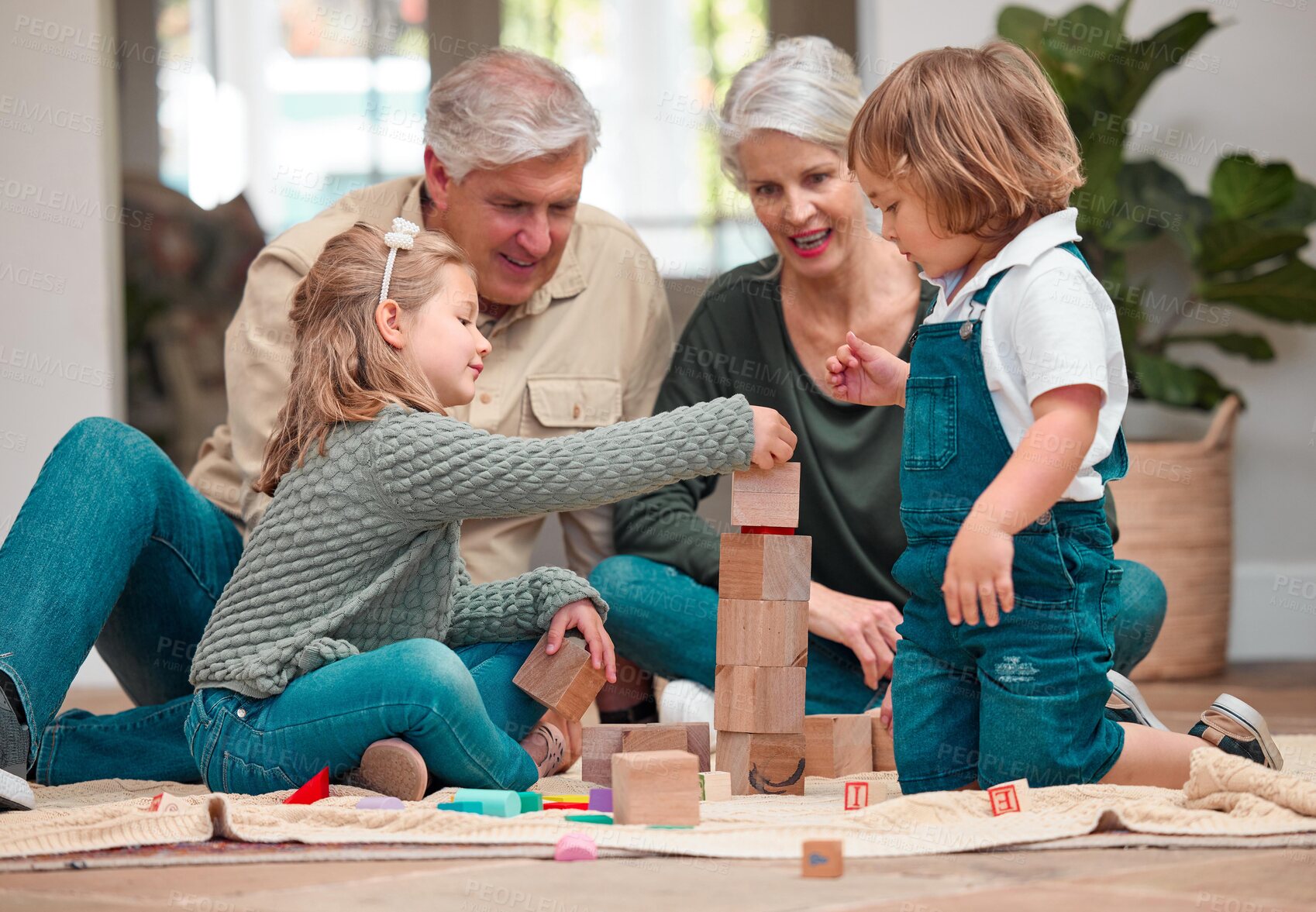 Buy stock photo Playing, wooden blocks and grandparents with children, house and bonding of family, growth and development. Games, kids and learning with toys, people and smile in living room, floor and fun in home