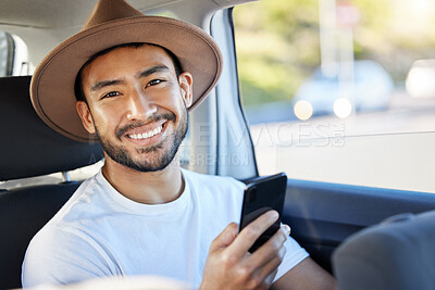 Buy stock photo Shot of a young man sitting in a car while using his phone